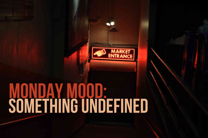 A dark stairwell with a red neon sign reading “Market Entrance" with a hand. Text overlay says “Monday Mood: Something Undefined.”