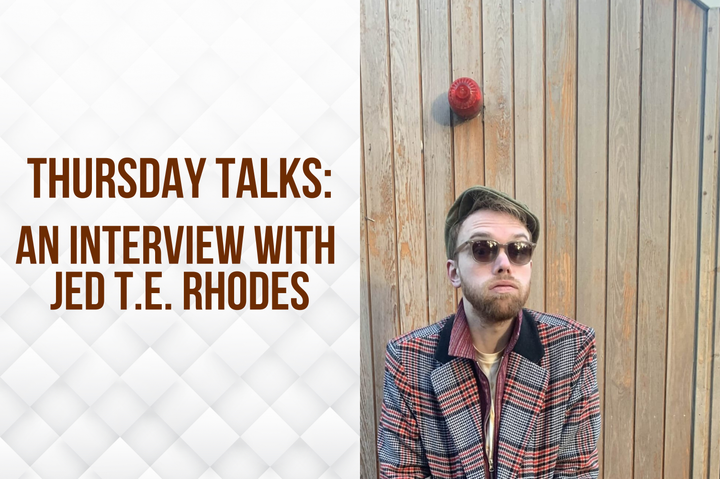 Person in sunglasses and a plaid jacket standing in front of a wooden wall. Text reads, “Thursday Talks: An Interview with Jed T.E. Rhodes.”